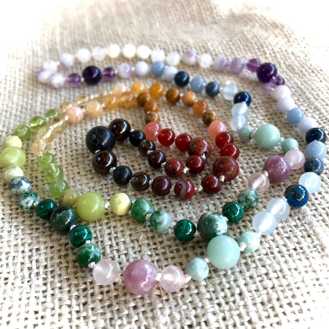 Colorful assortment of healing crystals and gemstones including shungite, amethyst, and quartz