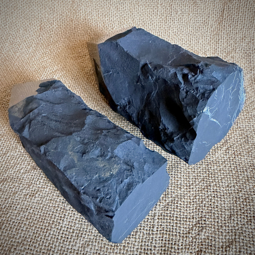 Large Raw Shungite Points flat end view, lying on burlap table