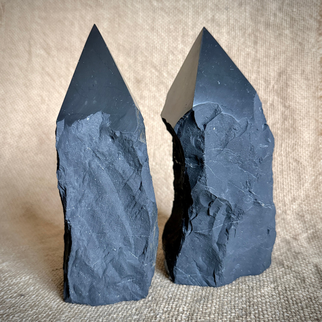 Large Raw Shungite Points standing upright on burlap covered table