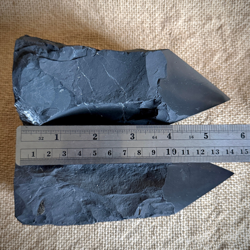 Large Raw Shungite Points lying on burlap with ruler for scale 