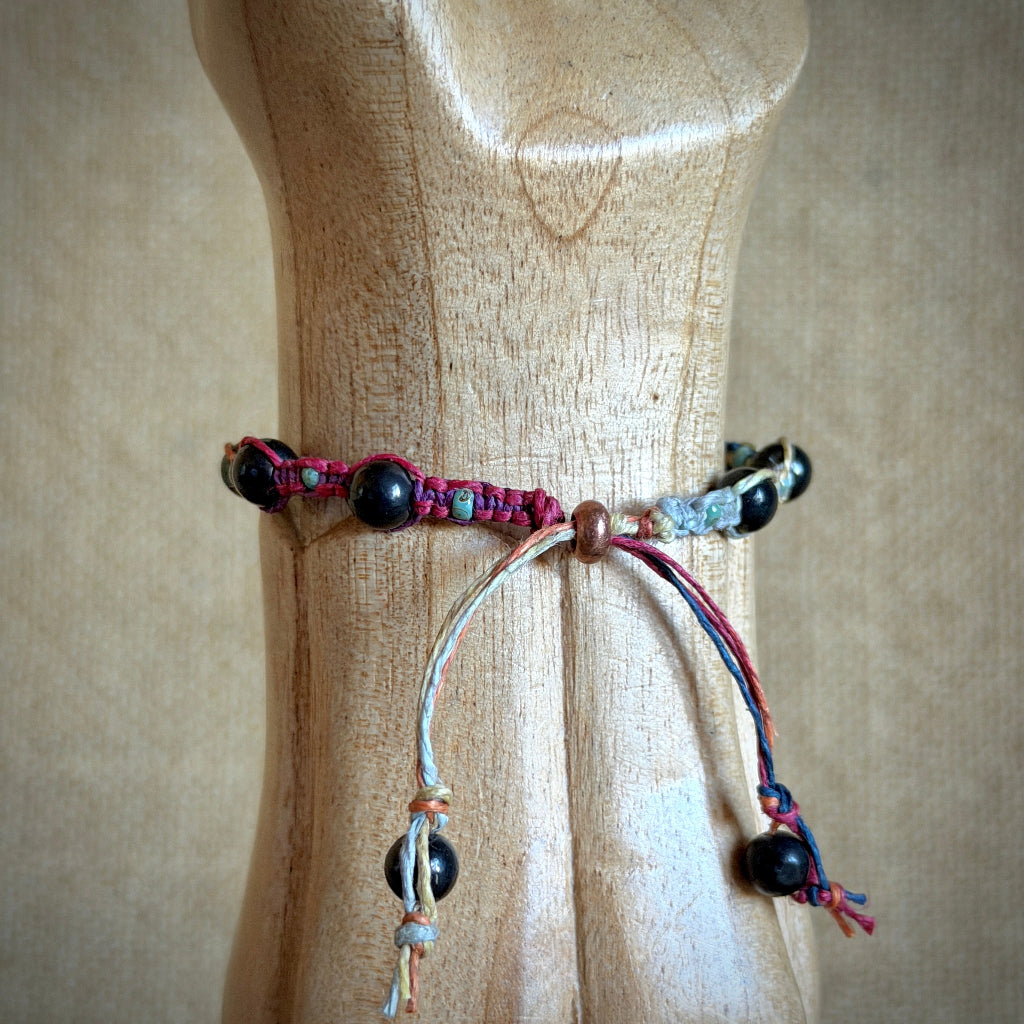 Shungite Macrame Bracelet with Variegated Hemp rainbow slider closure on wooden model wrist 