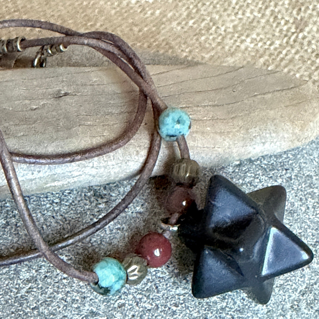 Shungite Merkaba Necklace on stone and wood background