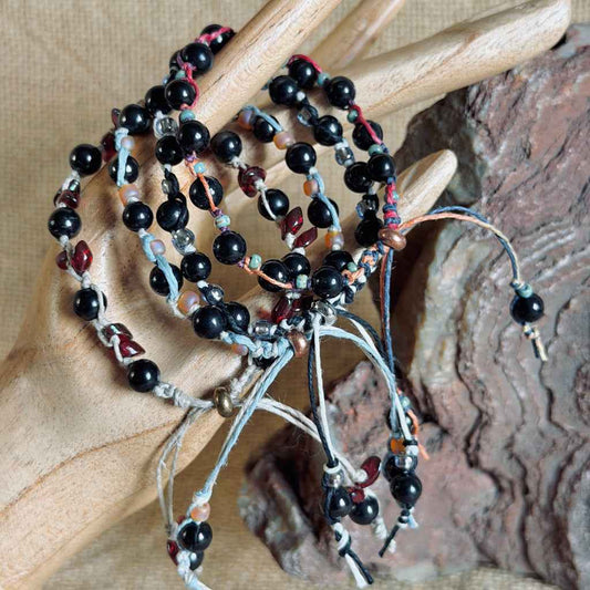 Stacked hemp and linen shungite beaded bracelets on wooden model hand